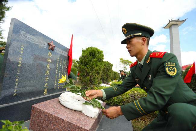 图为官兵向烈士献花.  马亮志摄